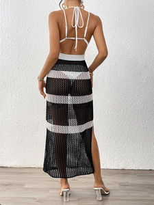 Detail view of crochet knit long dress with black and white stripes and side slit