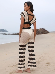 Detail of crochet knit beach set with contrast stripes on backless top and trousers