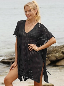 Detail of black crochet beach cover-up with openwork mesh and side fringe ties