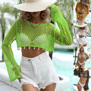 Detail of crochet mesh crop top featuring long sleeves and hanging shell decorations