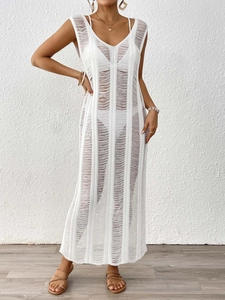 Close-up of white knitted crochet texture and vertical stripes on the long beach dress