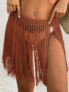 Detail of crochet fringe beach skirt with bohemian knit pattern and flowing tassels
