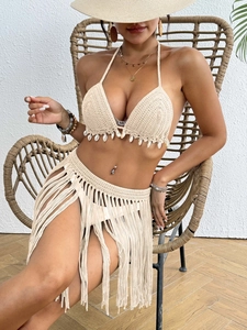 Detail of crochet beach cover-up featuring natural shells and long tassel fringe