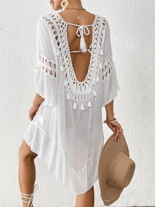 Detail of bohemian white beach cover-up with crochet lace, fringe trim and deep V-back