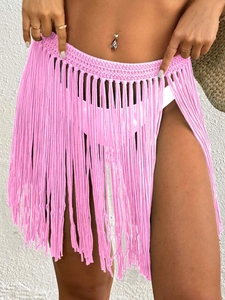 Detail of vibrant pink hand-crocheted beach skirt featuring long fringe and wide mesh waist