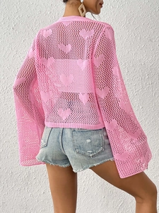 Close-up back view of pink open-knit cardigan with heart crochet pattern and bell sleeves