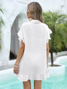 Détail des manches à volants et de l'ourlet sur une chemise de plage blanche