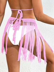 Detail of pink hand-crocheted beach cover-up skirt with long tassels and waist tie