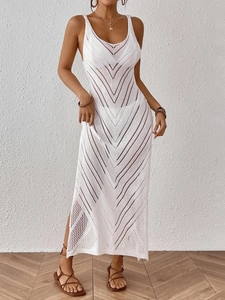 Détail du motif en crochet blanc et de la fente latérale sur la robe de plage ajourée