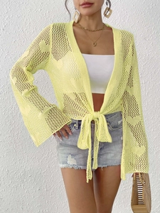 Close-up of light yellow crochet cardigan featuring bell sleeves and bow tie closure