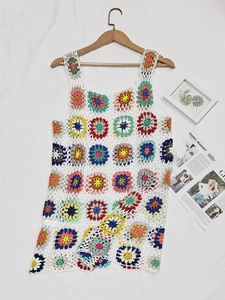Dettaglio di un abito boho all'uncinetto con motivi floreali colorati a quadretti della nonna