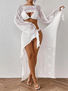 Detail of white crochet knit beach set featuring heart hollow-out patterns and tie-up design