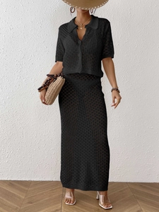Detail eines schwarzen Lochstrick-Zweiteilers mit Strickjacke und schmalem Maxirock