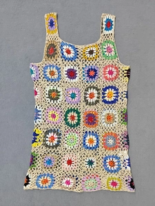 Dettaglio dell'abito da spiaggia bohémien fatto a mano all'uncinetto con fiori colorati