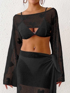 Close-up of black crochet hollow heart patterns on long sleeve beach cover-up top