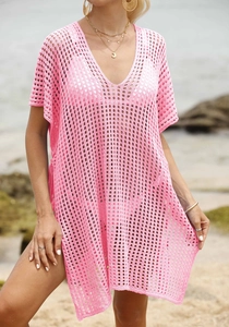 Detail of pink crochet beach cover-up featuring a deep V-neck and hollow-out mesh texture