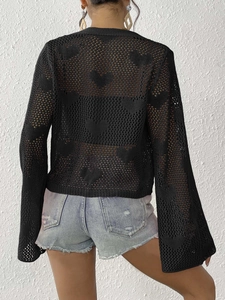 Detail of heart-shaped crochet hollow pattern on black long sleeve cardigan top