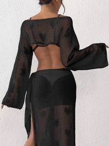 Detailed view of the black crochet heart pattern and knit texture on the flared sleeve