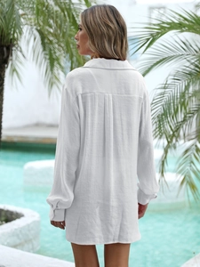 Rear view of white linen beach cover-up shirt with back pleat and relaxed long sleeves