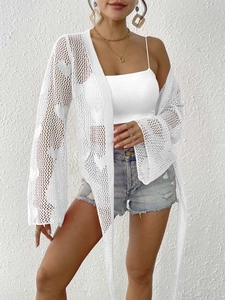 Close-up of intricate crochet knit texture and flared sleeve detail on white cardigan