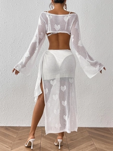 Detail of white knit beach set featuring heart hollow-out pattern and back lace-up skirt