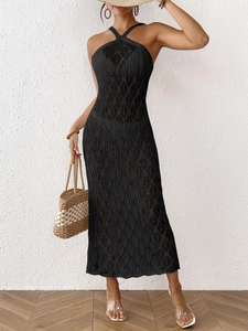 Detail of black crochet knit maxi dress with intricate leaf patterns and halter neckline