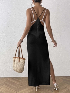 Detail of black knit backless beach dress with thin halter straps and a high side slit