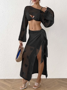 Close-up of black crochet beach set featuring hollow heart knit patterns and tie-up details