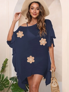 Detail of navy blue beach cover-up featuring 3D floral embroidery and textured fabric