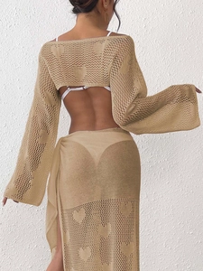 Detailed view of heart-shaped crochet knit pattern on khaki beach vacation cover-up set
