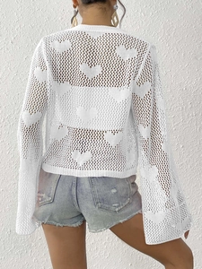 Bohemian white crochet cardigan with heart patterns and flared sleeves on a model