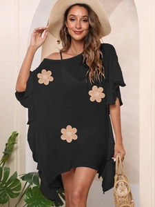 Detail of loose black summer dress featuring three beige straw sunflower appliques