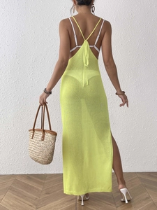 Back view of neon yellow knit beach dress featuring halter neck and high side slit detail