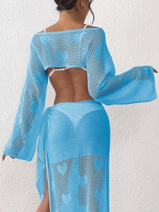 Detail of light blue crochet beach cover-up featuring heart patterns and openwork knit