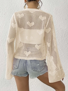 Close-up of heart-shaped crochet mesh design and flared sleeves on beige cover-up