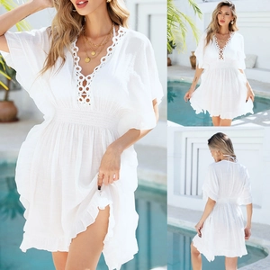 Détail de la tunique de plage blanche à col V avec dentelle et ourlet volanté