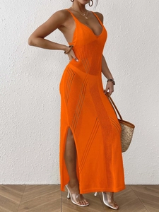 Detail of orange hollow-out knit dress with V-neck, high side slit and intricate texture