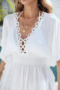 Détail du cache-maillot blanc bohème avec col V crocheté à la main et taille smokée