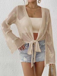 Detail of beige crochet knit cardigan featuring flared sleeves and geometric hollow texture