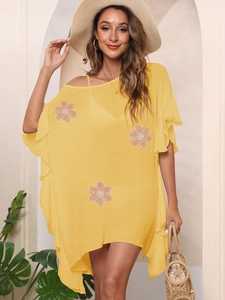 Detail of yellow beach cover-up featuring ruffled sleeves and white crochet floral embroidery