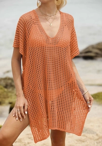 Close-up of orange crochet beach cover-up featuring intricate hollow knit textures