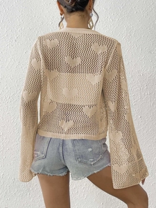 Detail of heart-shaped crochet pattern on back of apricot knit cardigan cover up