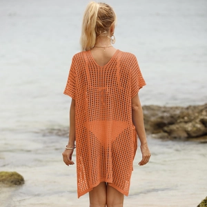Detail of vibrant orange knitted beach cover-up showing hollow-out texture on the back