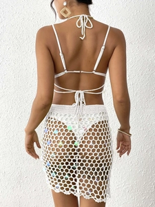 Detail of white crochet beach set showing sequin patchwork and hollow knit texture on back