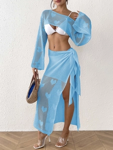 Detail of light blue knit set featuring heart-shaped cutout crochet and tie-waist skirt