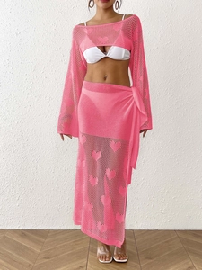 Detail of pink knit two-piece set featuring heart-shaped cutouts and texture