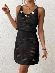 Dettaglio del set due pezzi in crochet nero con applicazioni di margherite bianche