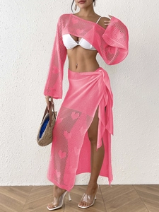 Detailed knit texture of pink heart-pattern crochet crop top and lace-up midi skirt