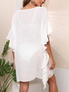 Detail of white ruffled sleeves on a sheer beach cover-up with a low back design