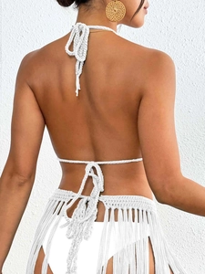 Detail of white handmade crochet bikini back with hanging tassels and tie-up halter straps